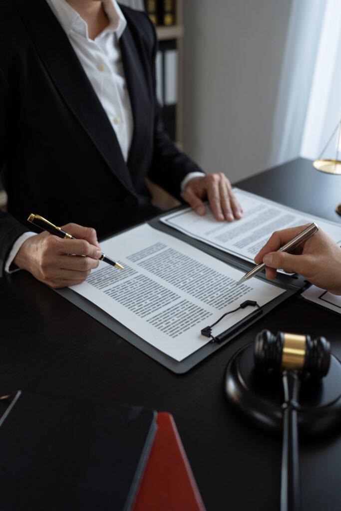 Businessmen and lawyers or legal advisors discuss legal treaty contract documents before signing contract business.